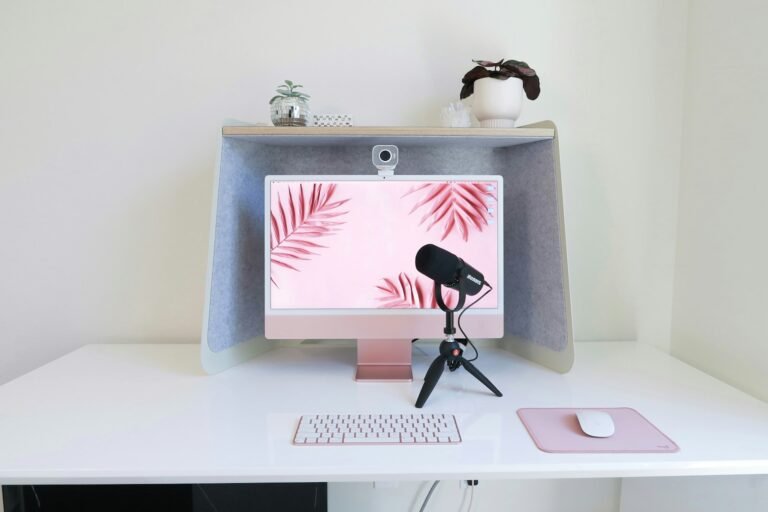 Setup Guides and Gear Reviews Simple streaming desk with a computer, a desktop microphone on a tripod and a webcam on top of the monitor